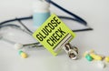 Stethoscope and white card with GLUCOSE CHECK text on blue background. Medical concept