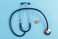 Stethoscope and wooden heart on blue background