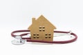 Stethoscope and wooden house. Image use for health medical care of family concept