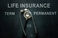 Stethoscope and words on the desk Life insurance term vs permanent.