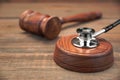 Stetoscope and Real Judges Gavel On Brown Wooden Background