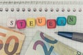 Steuern in german Tax concept with letter cubes and bank notes Royalty Free Stock Photo