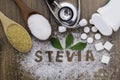 Sugar and Stevia leaf, sweetener tablets and medical stethoscope on wood table background. Royalty Free Stock Photo