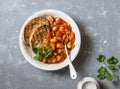 Stew beans in tomato sauce and grilled bread. Beans bruschetta. Delicious vegetarian appetizer on grey background