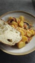 Stew with potatoes, carrots and sausage served with a slice of fresh bread on a ceramic plate Royalty Free Stock Photo