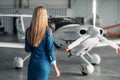 Stewardess against turboprop airplane in hangar