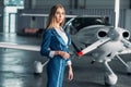 Stewardess against turboprop airplane in hangar