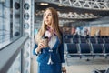 Stewardess with hand luggage and coffee in airport