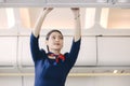 The stewardess helps the passengers to put their luggage in the cabin of the plane. Stewardess in the airplane