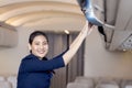 The stewardess helps the passengers to put their luggage in the cabin of the plane. Stewardess in the airplane