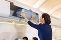 The stewardess helps the passengers to put their luggage in the cabin of the plane. Stewardess in the airplane