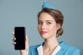 stewardess holding smartphone with empty screen in hand
