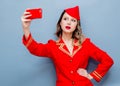 Stewardess wearing in red uniform with mobile phone