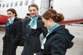 Stewardesses standing on runway near airplane jet Royalty Free Stock Photo