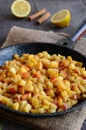 Stewed apples with cinnamon and lemon on iron pan