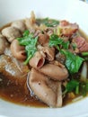 Stewed beef noodles Clear white cup placed on a loft style cement floor.