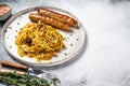 Stewed cabbage with mushrooms and meat sausages on a plate. White background. Top view. Copy space Royalty Free Stock Photo