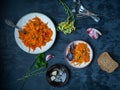 Stewed carrots with garlic and parsley on light plates on a dark background