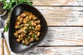 Stewed chicken liver hearts in a plate. White wooden background. Top view. Copy space Royalty Free Stock Photo