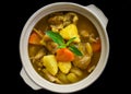 Stewed chicken with potato and vegetables on blue plate isolated on black background top view Royalty Free Stock Photo