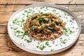 Stewed chicken stomachs with vegetables and buckwheat. Wooden background. Top view