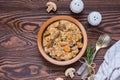 Stewed diced turkey with mushrooms in a creamy sauce in a clay plate on a brown wooden background. Turkey recipes