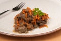 Stewed liver with carrots on a plate. close up