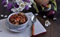 Stewed meat and beans in a bowl on a dark wooden table.