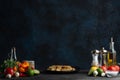 Stewed potatoes on a background of fresh vegetables, cooking potato dishes, dark blue background with space, recipe book