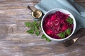 Stewed red cabbage with apples, spices and greens on a wooden background
