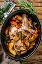 Stewed whole lamb shoulder in a baking dish. Wooden background. Top view