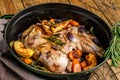 Stewed whole lamb shoulder in a baking dish. Wooden background. Top view