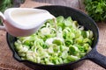 Stewing leek slices in a frying pan with cream Royalty Free Stock Photo