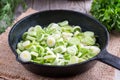 Stewing leek slices in a frying pan on a hot plate Royalty Free Stock Photo