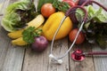 Sthetoscope and fresh colorful vegetables ingredients fo vegan and healthy cooking or salad making on rustic background, top view,