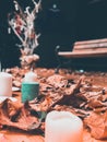 stic candles on the wooden platform with aurumn leaves