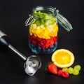 Stick blender with variety of colorful fruits