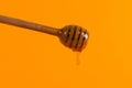 A stick for honey and a small jar, concept on a yellow background