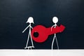 Stick man couple figure carrying a big red key in dark background with copy space. Buying and owning new house or car.