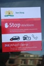 Sticker on car to warn that the municipality put a wheel clamp on it and will be removed when parking fine is paid in Den Haag, th