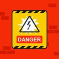 Sticker caution electricity on the red wall. Royalty Free Stock Photo