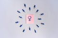 Sticker with a female sign in the center of the blue push pins with their spike facing the woman. The concept of discrimination a