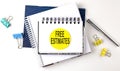 Sticker with FREE ESTIMATES text on the notebooks on the white background