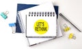 Sticker with LET`S RETHINK text on notebooks on the white background Royalty Free Stock Photo