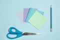 Sticker papers, scissors, pen. Monochrome stylish composition in blue color. Top view, flat lay.