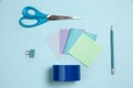 Sticker papers, scissors, pen. Monochrome stylish composition in blue color. Top view, flat lay.