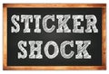 STICKER SHOCK words on black wooden frame school blackboard