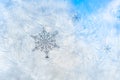 Sticker snowflakes on ice frosted window glass with blue sky seen in the background Royalty Free Stock Photo