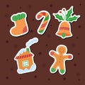 Stickers of New Year and Christmas cookies - a sock, a bell, a candy, a ginger man and a house on a brown background with stars,