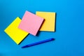 Stickers for notes and pen lie on a blue background Royalty Free Stock Photo